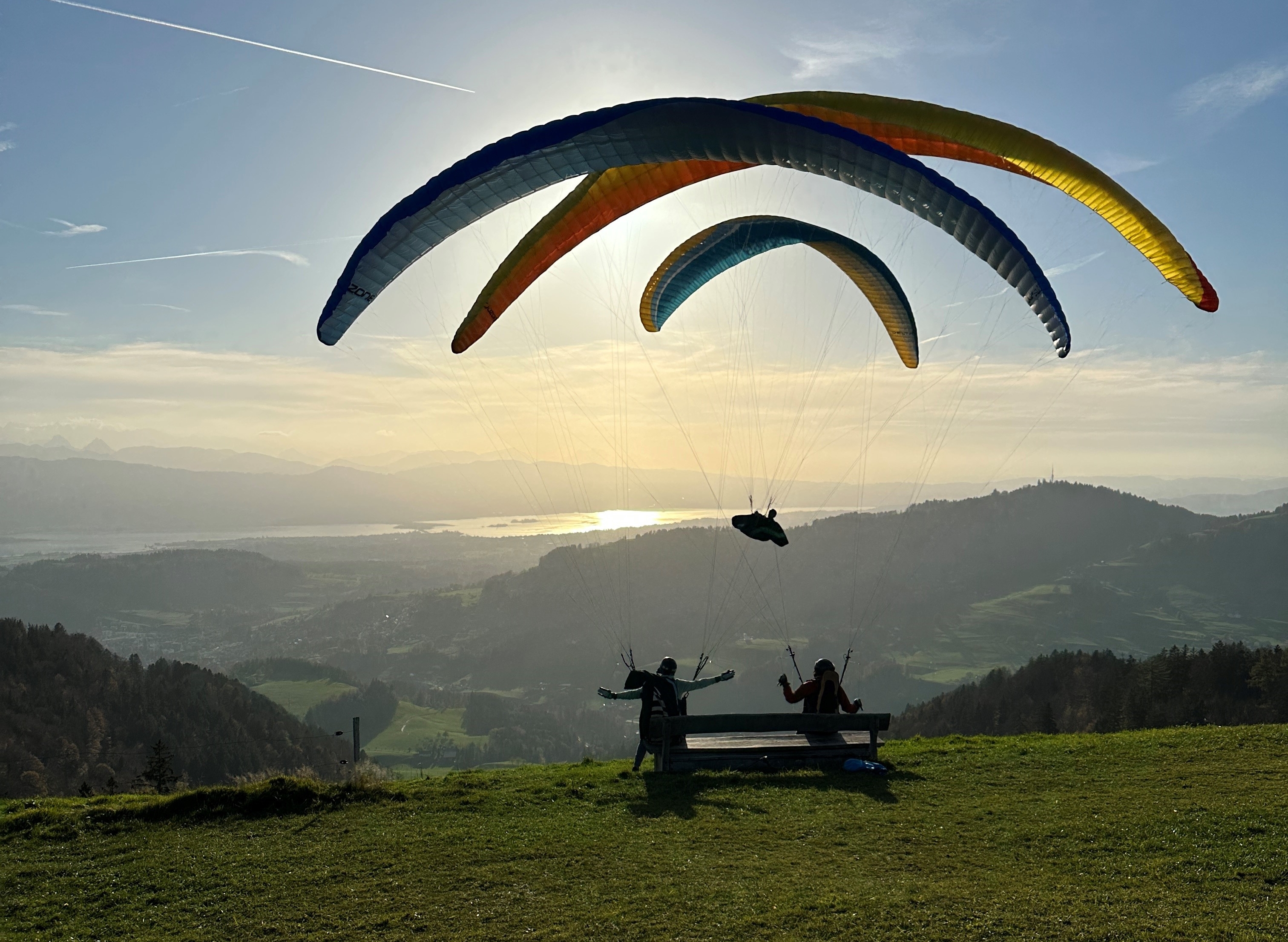 Gleitschirmflieger über Alpenpanorama in Abendstimmung